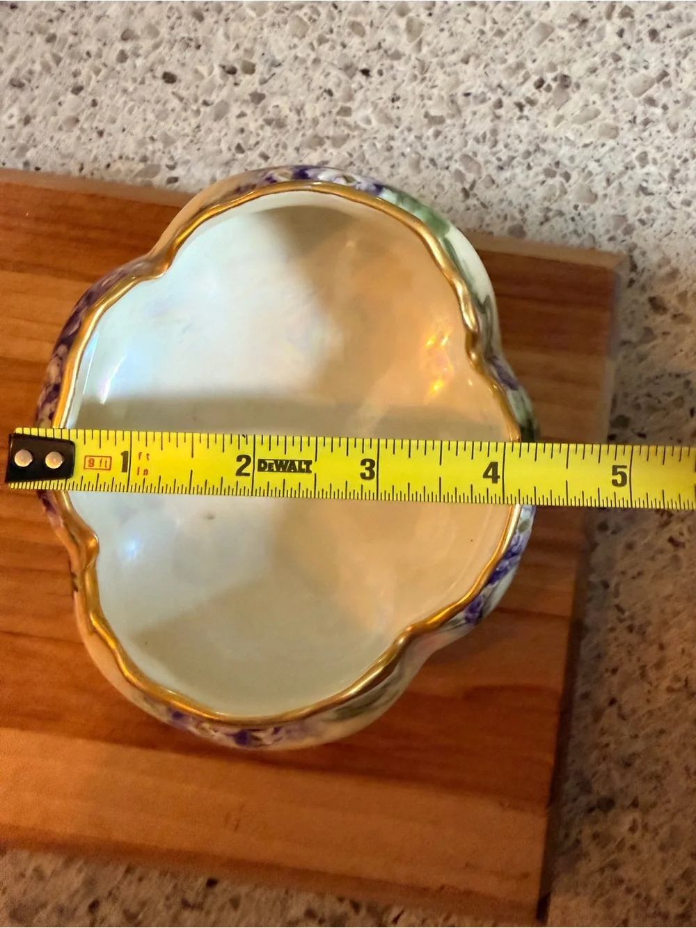 A hand-painted porcelain footed bowl with gilded rim and floral decoration.